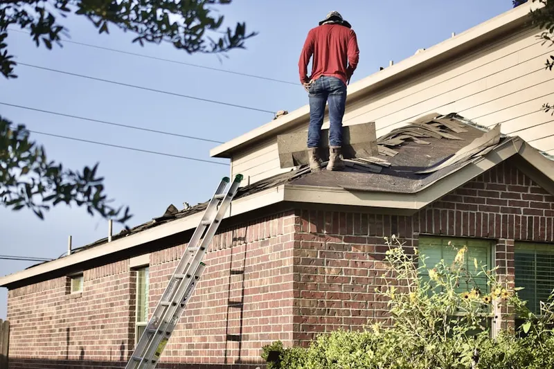 Professional roofer working on a residential roof in Kirby Manor
